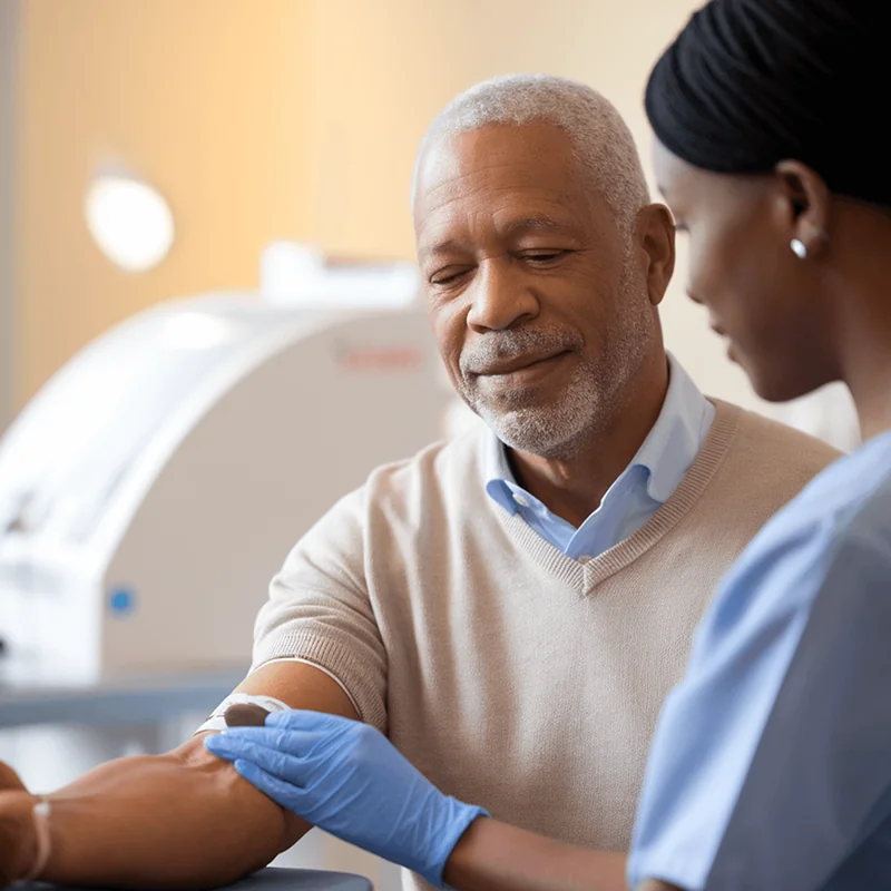 Elderly man participating in a blood draw, symbolizing proactive health monitoring for general longevity and well-being.