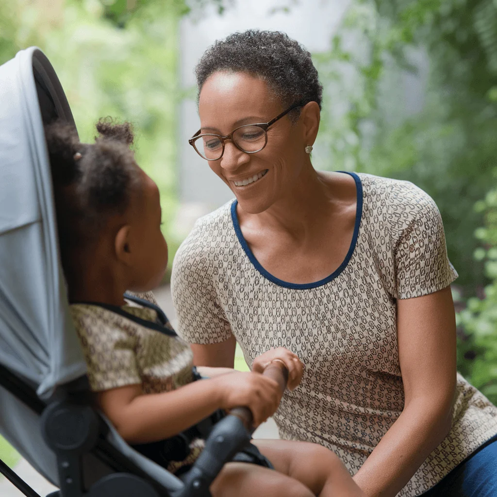 Smiling middle-aged woman interacting with a baby in a stroller, promoting healthy lifestyle and weight management.